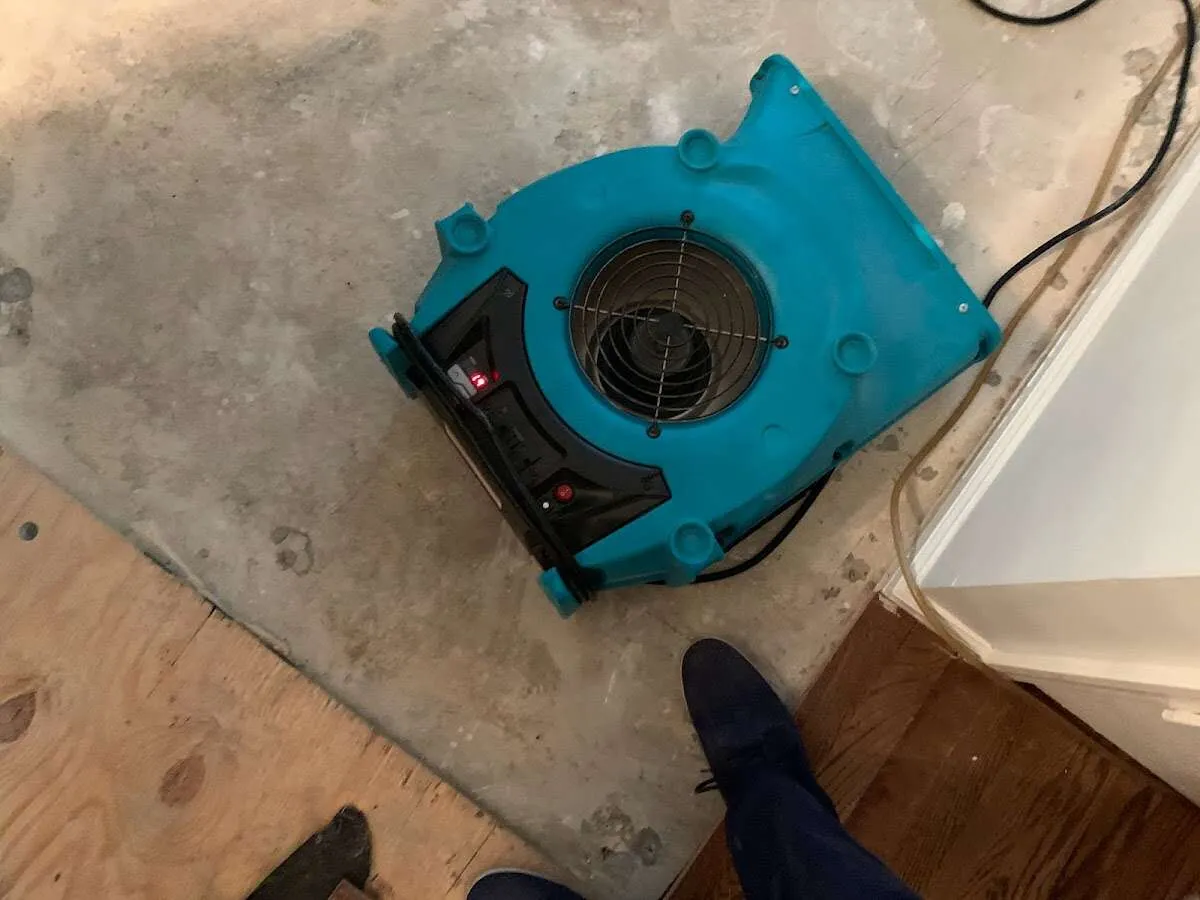 Air mover drying subfloor during Commercial Water Damage Restoration in Preston